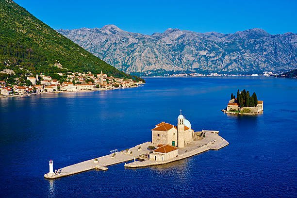 Alt text Perast waterfront with Our Lady of the Rocks island in the Bay of Kotor