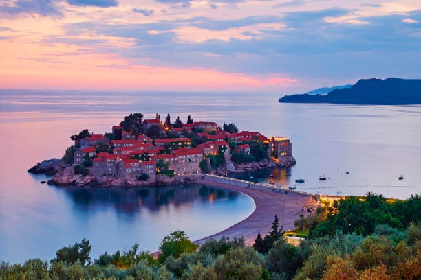 Montenegro in September Sveti Stefan island at golden hour with warm sea and very few tourists representing the best month