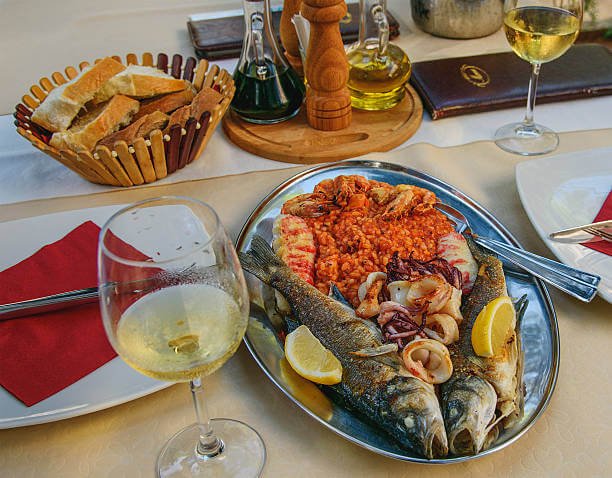 Traditional Montenegrin food fresh grilled seafood calamari and local wine on a coastal restaurant terrace overlooking the Adriatic